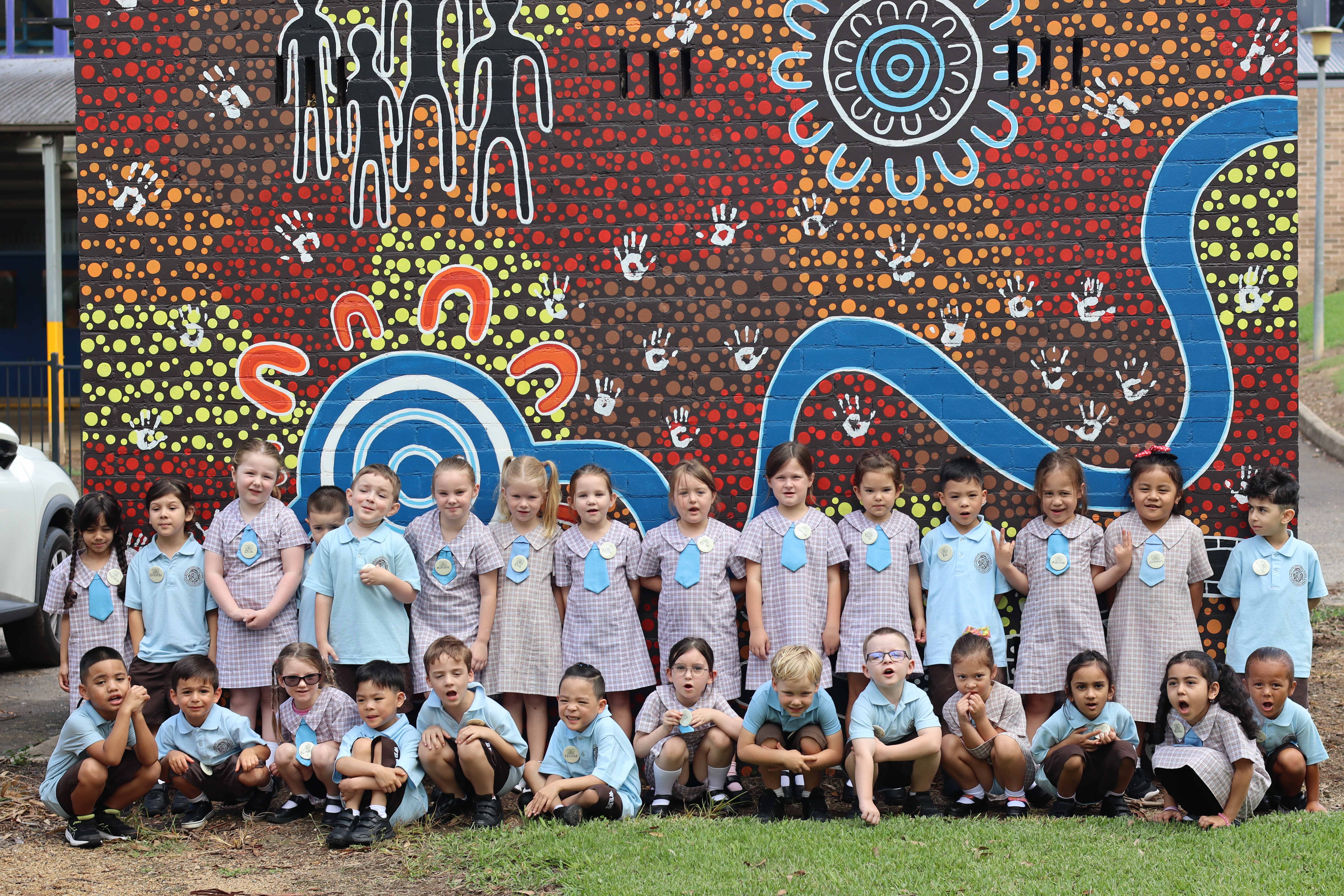 kindy in front of  mural